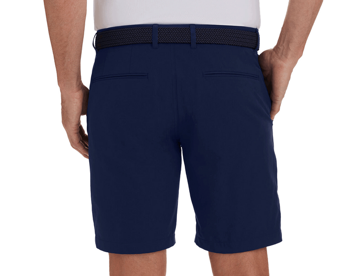 The Harwood Short: Navy, featuring welt back pockets, non-slip waistband, and ball-marker pocket, worn with a dark woven belt and white shirt.