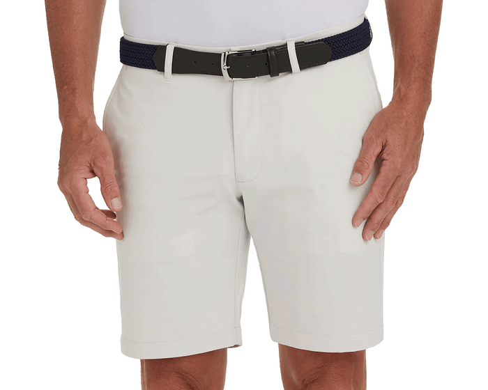 The Harwood Short: Stone, featuring a non-slip waistband and ball-marker pocket, worn with a dark navy belt, offers classic style and performance.