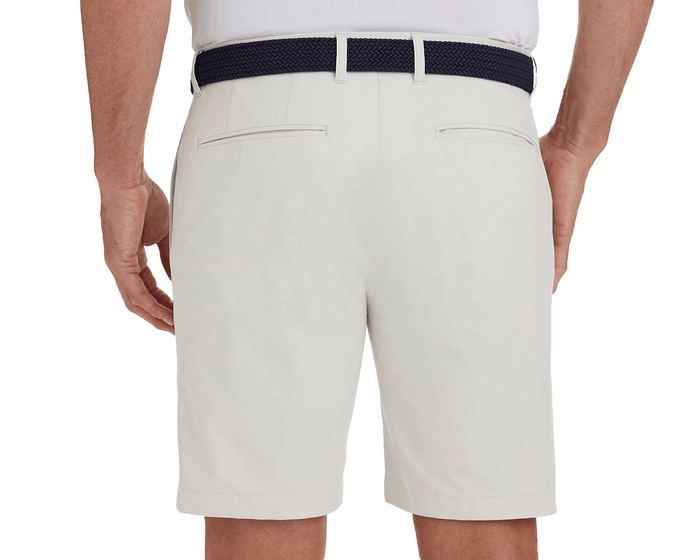 Back view of a man wearing The Harwood Short: Stone, showcasing welt back pockets and a dark navy braided belt, highlighting the shorts' classic style and comfort features.