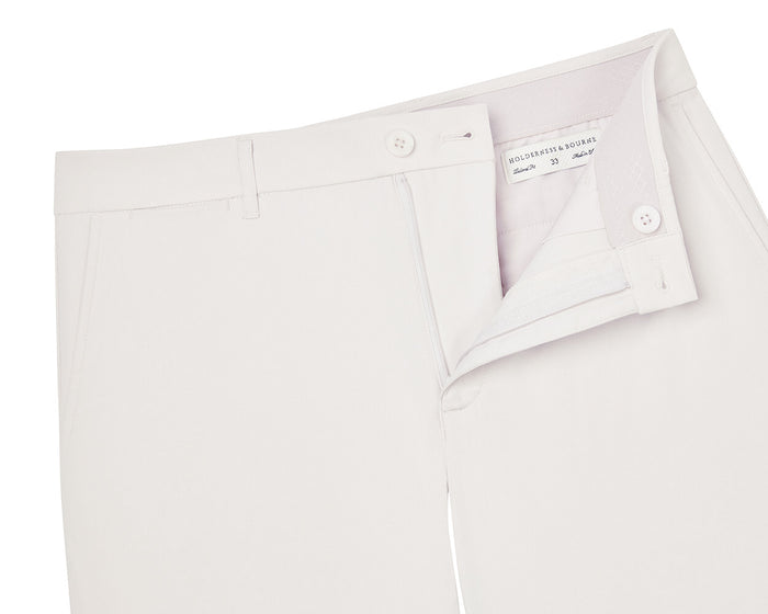 The Harwood Short: Stone, featuring a partially open button and zipper fly, waistband with belt loops, side pockets, and Holderness & Bourne label inside.