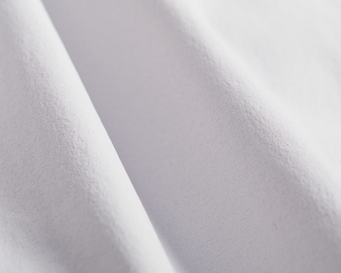 Close-up of The Harwood Short: Stone, showcasing its smooth cotton-like fabric and subtle weave, emphasizing its soft drape and performance design details.