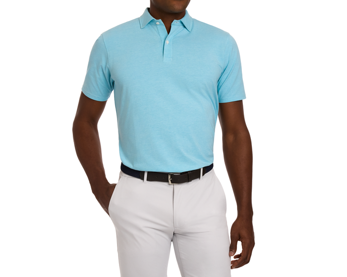 Man wearing The Hatcher Shirt: Harbor & White, a light blue polo with a structured collar, tucked into light gray pants, showcasing a dark woven belt.