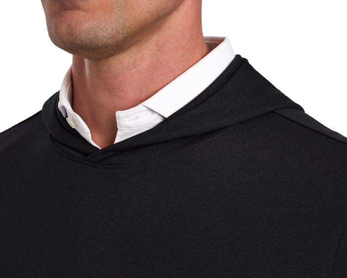 The Jackson Hoodie: Black, showcased over a white button-down shirt, features a sleek, lightweight design without drawstrings or pouches, perfect for golf.