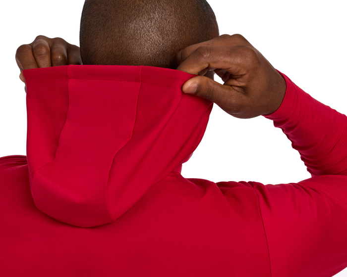 Person wearing The Jackson Hoodie: Liberty, pulls up the hood, showcasing its streamlined, lightweight design, ideal for unobstructed movement during golf.
