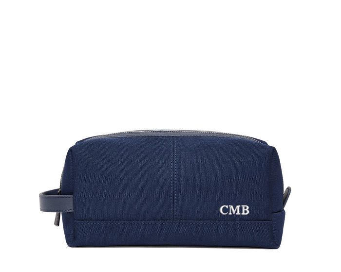 The Littler Dopp Kit: Navy Ballistic - White Embroidery, featuring a rectangular design with a top zipper, side handle, and personalized initials CMB.
