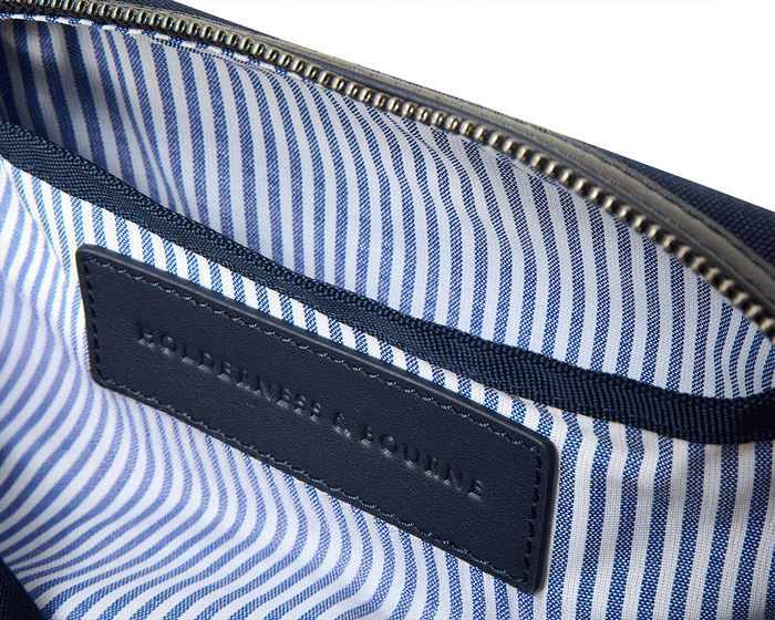 The Littler Dopp Kit: Navy Ballistic - White Embroidery, featuring a blue-and-white striped lining, top zipper, and embossed leather label inside.