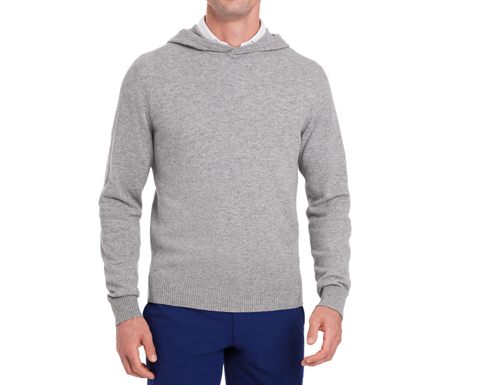 The Logan Hoodie Sweater: Heathered Gray, a light-gray knitted pullover over a white shirt, paired with navy trousers, showcasing ribbed hem, hood, and cuffs.