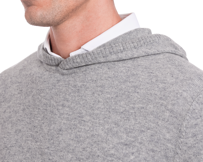 The Logan Hoodie Sweater in Heathered Gray, showcasing ribbed edging and layered over a white collared shirt, highlights its minimalist and versatile design.