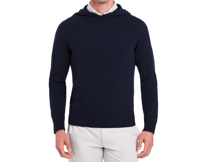 The Logan Hoodie Sweater: Heathered Navy, crafted from Merino wool and cashmere, shown over a white shirt, featuring ribbed hem, hood, and cuffs.