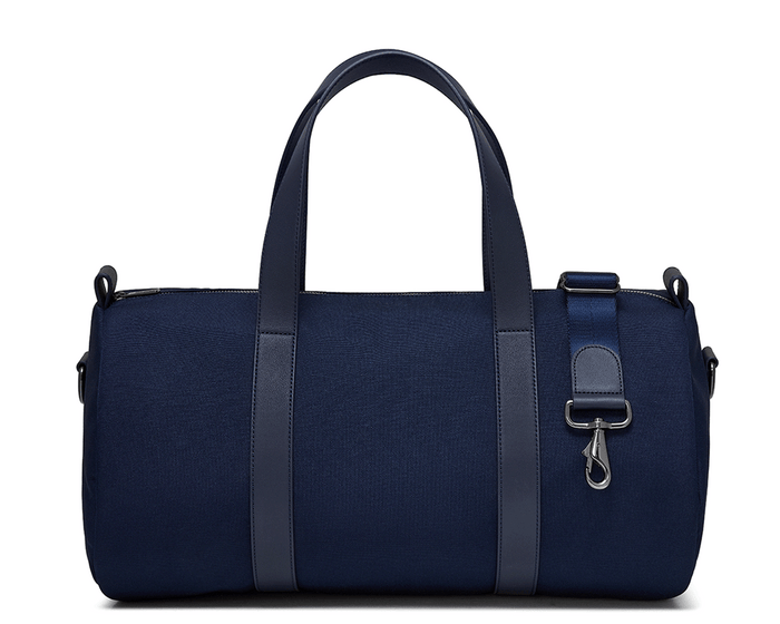 The Marston Banker Bag: Navy Ballistic, featuring top carry handles, adjustable shoulder strap, Napa leather trim, oxford stripe lining, and gunmetal hardware. Ideal for gym or travel.