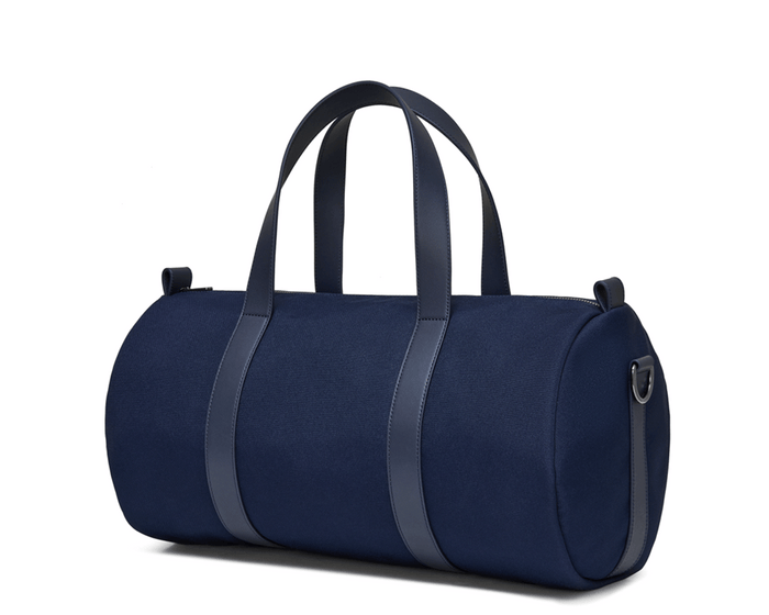 The Marston Banker Bag: Navy Ballistic, a sleek cylindrical duffel with Napa leather accents, oxford stripe lining, and gunmetal hardware, ideal for versatile use.
