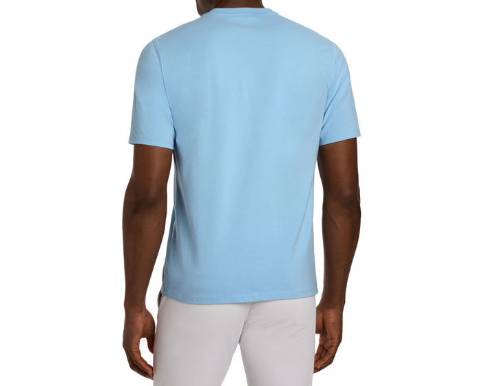 Back view of The Mason T-Shirt: Vista Blue, showcasing its classic short-sleeve design in Peruvian pima cotton, worn with light trousers against a white background.