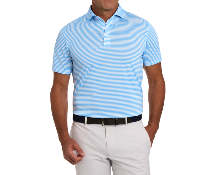 Man wearing The Maxwell Shirt: Vista Blue & White, a light blue, striped polo with a classic collar, tucked into beige trousers with a woven belt.