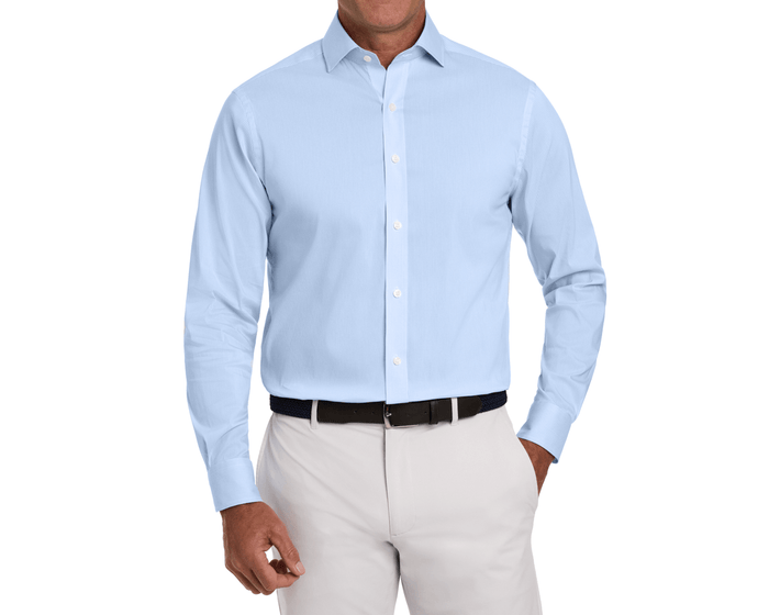 The McAllister Shirt: Vista Blue, showcasing a light-blue button-down with a structured collar, tucked into beige trousers, highlighting breathability and wrinkle resistance.