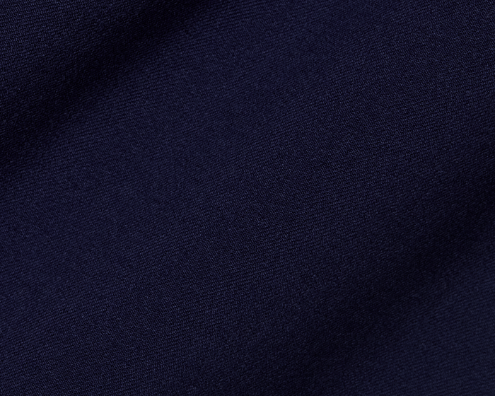 Close-up of The McDaniel 5 Pocket Pant: Navy, showcasing its fine woven texture, highlighting wrinkle-resistant, quick-dry performance fabric with eco-friendly recycled polyester and elastane blend.