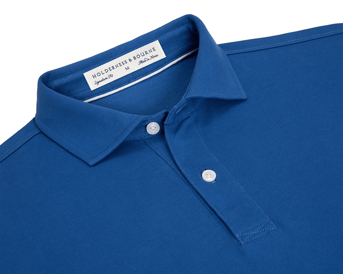 The Neville Shirt: Maidstone Blue, a blue polo with classic collar, two-button placket, featuring a woven label inside the collar, laid-back signature fit.