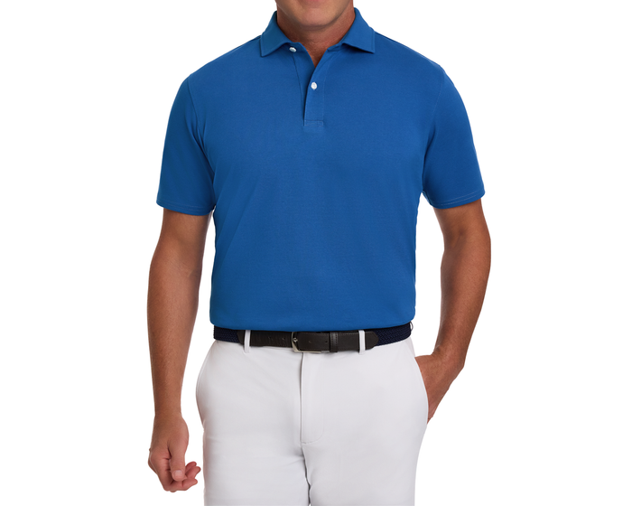 The Neville Shirt: Maidstone Blue, a short-sleeve polo in soft Peruvian Pima cotton blend, shown tucked into white pants with a dark belt.