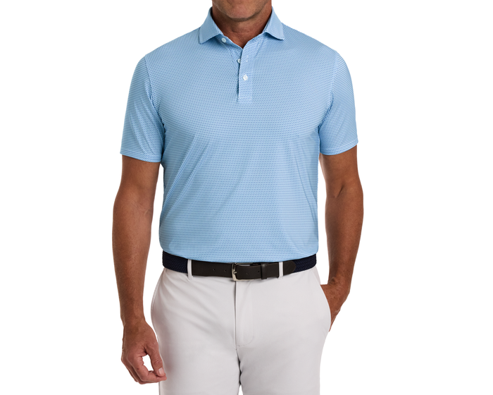 The Norman Shirt: Harbor & Maidstone Blue, a light blue polo with a geometric pattern, UPF 50+ protection, tucked into light trousers with a dark belt.