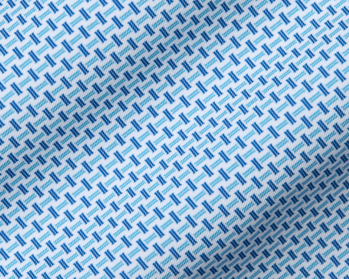 The Norman Shirt: Harbor & Maidstone Blue features a white base with a blue geometric pattern, offering UPF 50+, moisture wicking, and four-way stretch for comfort.