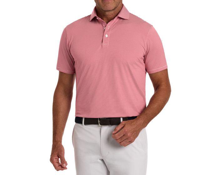 Man wearing The Perkins Shirt: Liberty Red & White, a striped polo with a structured collar, tucked into light-gray trousers, showcasing a casual yet polished look.