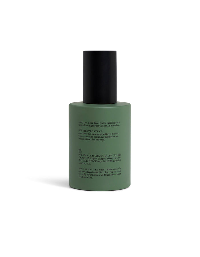 Green Fount Society Body Serum bottle turned backward with black cap on a white background