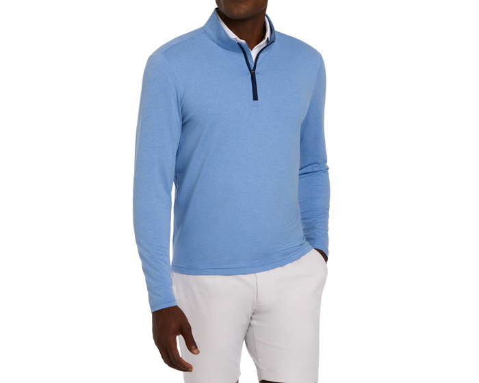 Man wearing The Royce Quarter-Zip: Heathered Horizon Blue, a textured long-sleeve pullover with dark-trim collar, paired with beige shorts, hand in pocket.