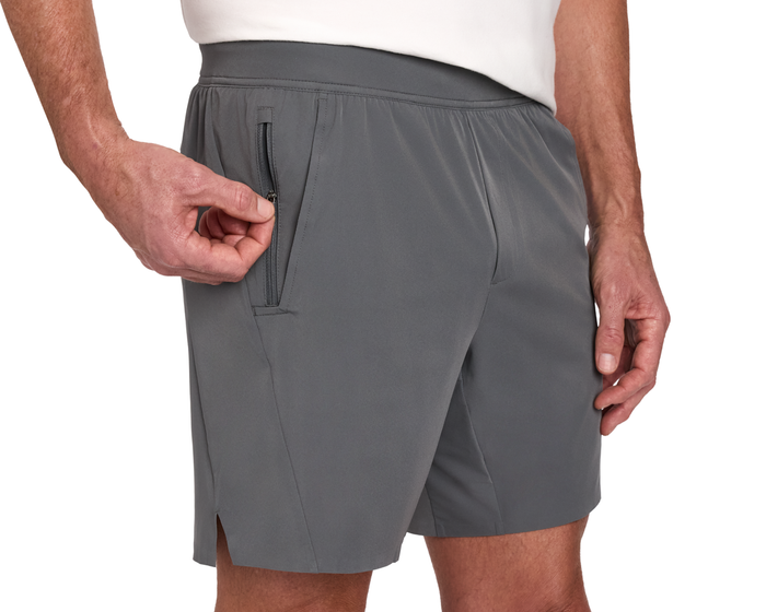 The Saunders Short: Iron Gray, featuring a zippered pocket on the right thigh, worn with a white shirt. Ideal for workouts with its quick-drying, stretch fabric.