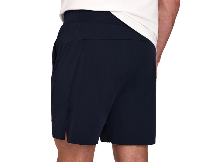 The Saunders Short: Navy, showcasing lightweight, stretchy fabric with a tonal logo, small back pocket, and athletic design.