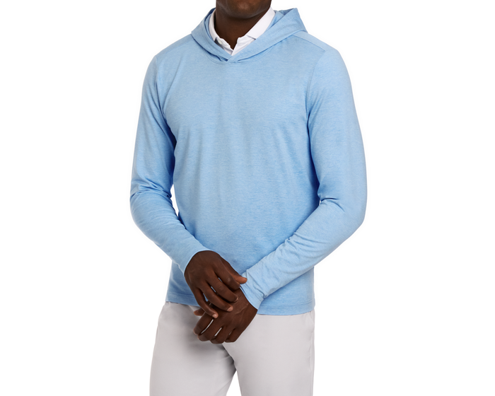 Man wearing The Stowe Hoodie: Heathered Vista Blue over a white shirt with light-gray pants. Features set-in sleeves and athletic drop-tail hem.