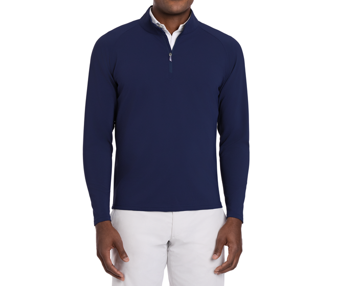 Person wearing The Stuart Quarter-Zip: Navy, showcasing its textured rib fabric over a white shirt, paired with light-grey pants, highlighting versatility and softness.