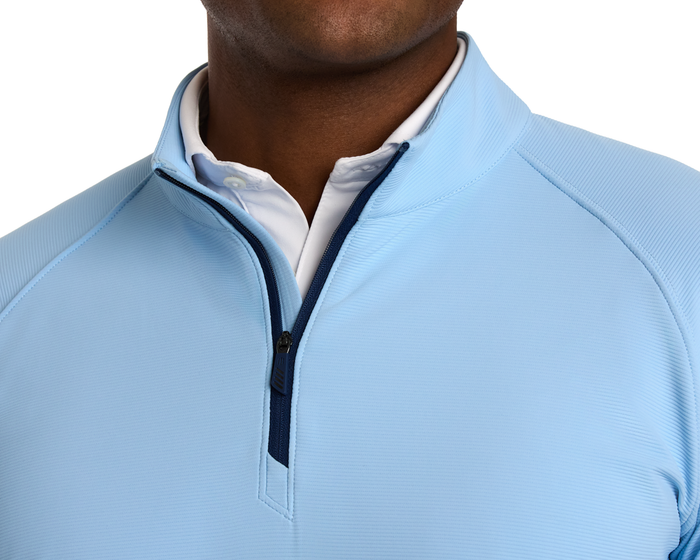 Close-up of The Stuart Quarter-Zip: Vista Blue, featuring a textured rib fabric with a dark navy zipper, layered over a white collared shirt.
