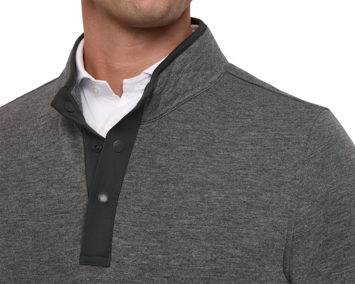 The Sullivan Quarter-Snap: Heathered Charcoal features a mock-neck pullover with black snap-button placket, layered over a white collared shirt, showcasing casual elegance and warmth.