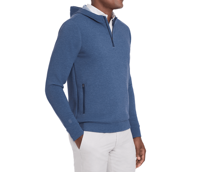 The Tilley Quarter-Zip Hoodie: Heathered Andover, features a sleek silhouette with a zipper neck and hip pockets, layered over a collared shirt.
