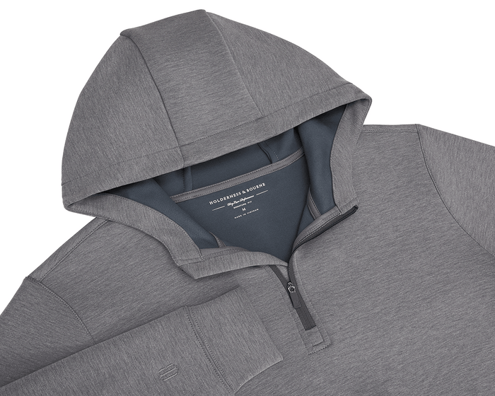 The Tilley Quarter-Zip Hoodie: Heathered Charcoal, features a sleek silhouette with a hood and partial front zipper, showcasing Holderness & Bourne's label. Ideal for versatile wear.