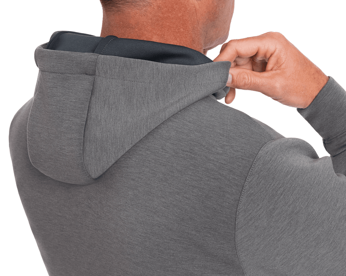 The Tilley Quarter-Zip Hoodie: Heathered Charcoal, shown from the back with a hand adjusting the hood, features a sleek silhouette and midweight performance fabric.