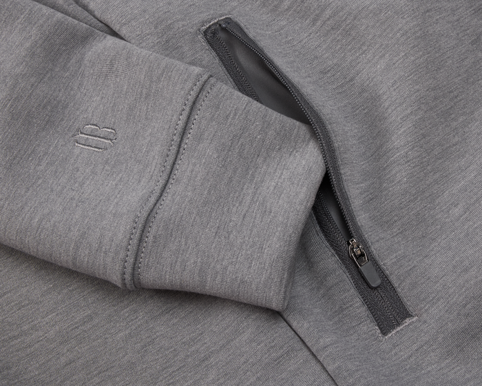 The Tilley Quarter-Zip Hoodie: Heathered Charcoal features a ribbed cuff, tonal logo, and zippered pocket, showcasing its versatile, sleek design and soft, mid-weight knit.