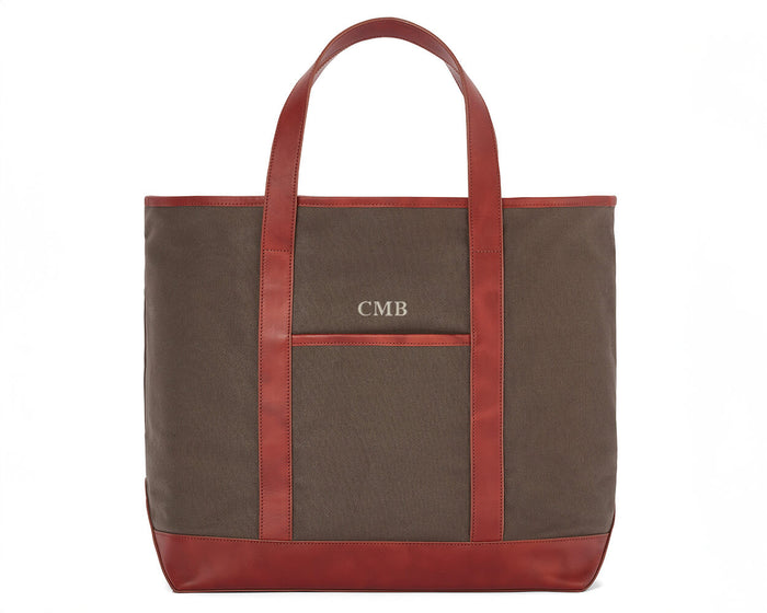 The Travis Tote Bag Cotton Twill: Scotch Green - Rye Embroidery, features a brown canvas with leather trim, monogrammed CMB above a front pocket.