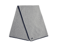 The Van Pelt Blanket: Heathered Gray, a light-grey quilted blanket with diamond stitching, dark-navy trim, and a minimalist logo embroidered near one corner.
