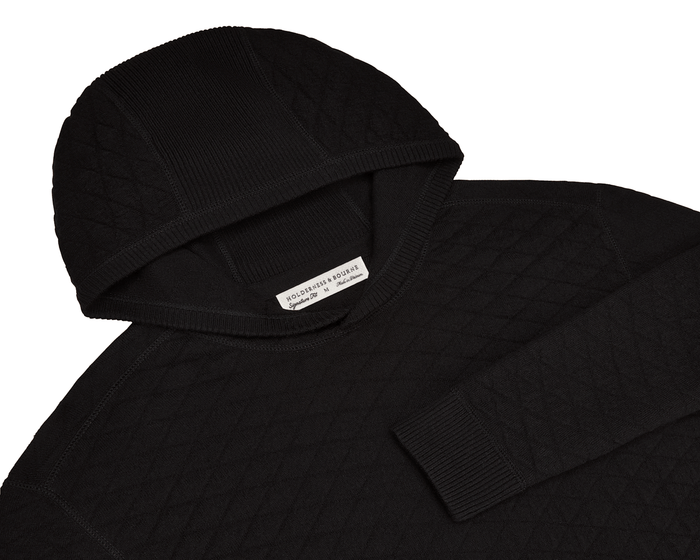 The Wallace Hoodie Sweater: Black features a quilted knit, ribbed hood and cuffs, and a label reading “Holderness & Bourne, Signature Fit, M.”