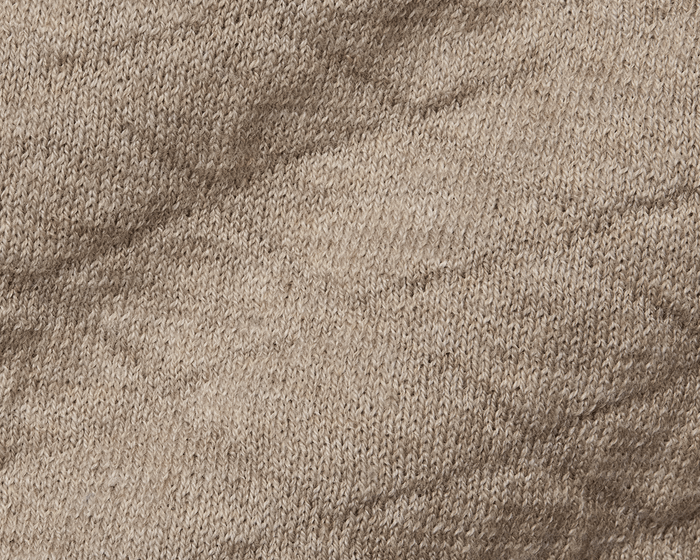Close-up of The Wallace Hoodie Sweater: Heathered Light Dune, showcasing intricate knit stitches and texture in 100% Egyptian cotton, highlighting its quality and warmth.