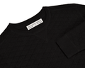 The Ward Crewneck Sweater: Black, showcases a diamond-quilted texture, crafted from soft Egyptian cotton, with a visible “HOLDERNESS & BOURNE” label inside the collar.