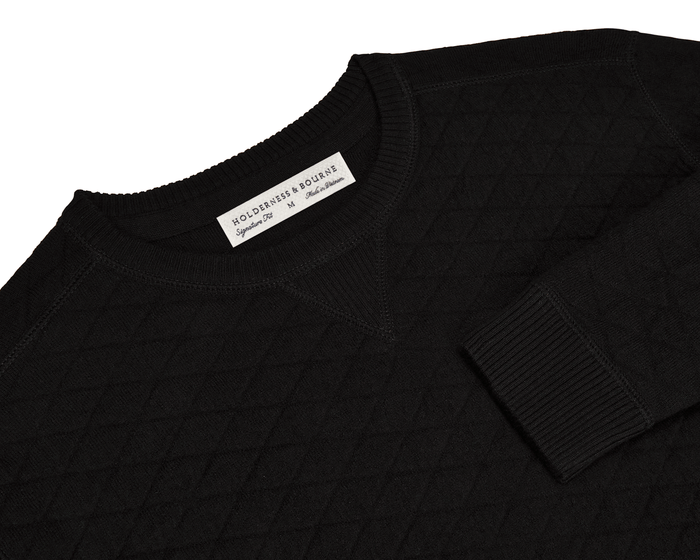 The Ward Crewneck Sweater: Black, showcases a diamond-quilted texture, crafted from soft Egyptian cotton, with a visible “HOLDERNESS & BOURNE” label inside the collar.