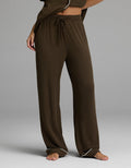 A person is shown from the waist down, standing barefoot on a gray background, wearing Cozy Earth’s Women’s Bamboo Rib-Knit Classic Pajama Pant in brown with a comfortable drawstring waist.|Color:Espresso