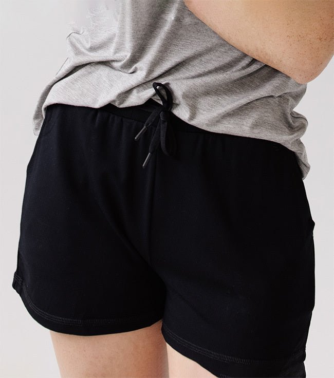 Person wearing Cozy Earth Brushed Bamboo Jogger Shorts in black and a gray top |Color:Black