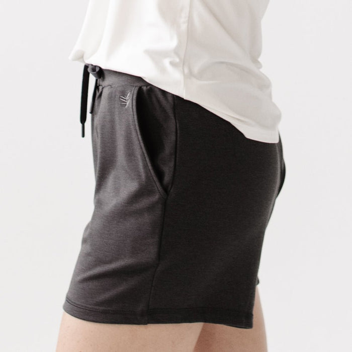 Person turned to the side wearing Cozy Earth Brushed Bamboo Jogger Shorts in dark grey and a white top on a light background |Color:Charcoal