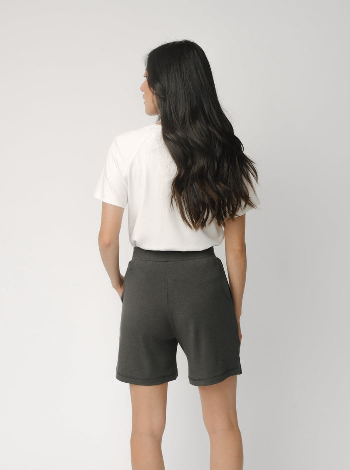 Woman wearing a white t-shirt and grey Cozy Earth Brushed Bamboo Mid-Length Shorts shorts on a plain background |Color:Charcoal