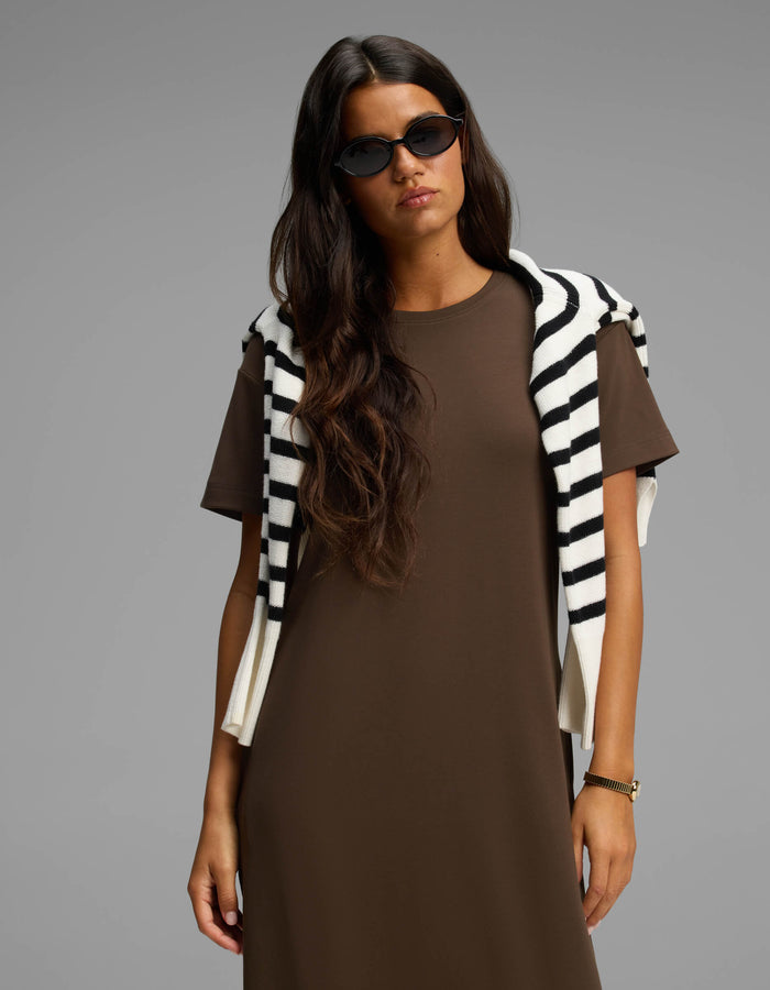 A woman with long brown hair wearing black sunglasses and a Cozy Earth Women's Brushed Bamboo Midi Dress stands against a plain gray background, with a black-and-white striped sweater draped over her shoulders.|Color:Espresso