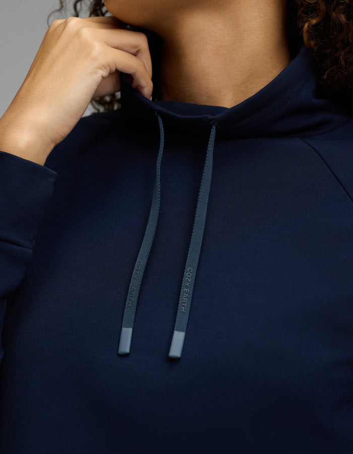A person wearing the Cozy Earth Women’s Brushed Bamboo Mock Neck in navy, holding the collar near their chin. Only the lower part of their face and hand are visible.|Color:Navy