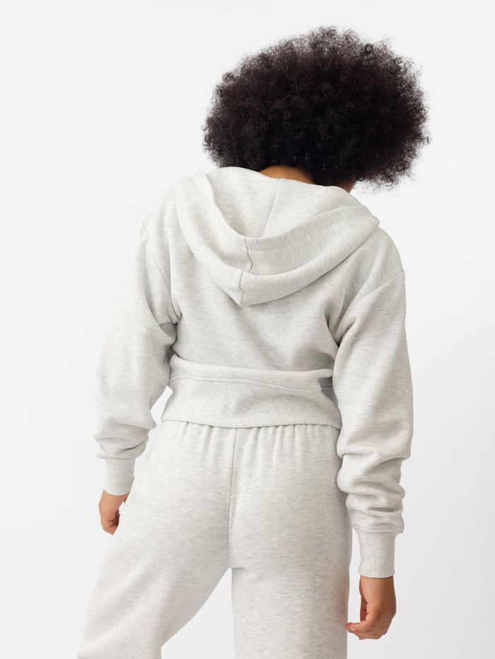 Woman wearing Heather Grey CityScape Cropped Full Zip with white background |Color: Heather Grey