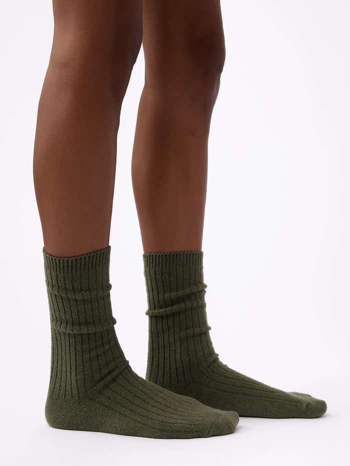 Person wearing Cozy Earth Plush Lounge Calf Sock 1-Pack in Olive |Color:Olive